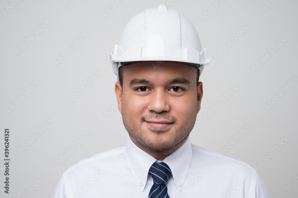 Smiling young asian civil engineer wearing helmet hard hat standing on isolated white background. Mechanic service concept. Smiling young asian civil engineer wearing helmet hard hat standing on isolated white background. Mechanic service concept.