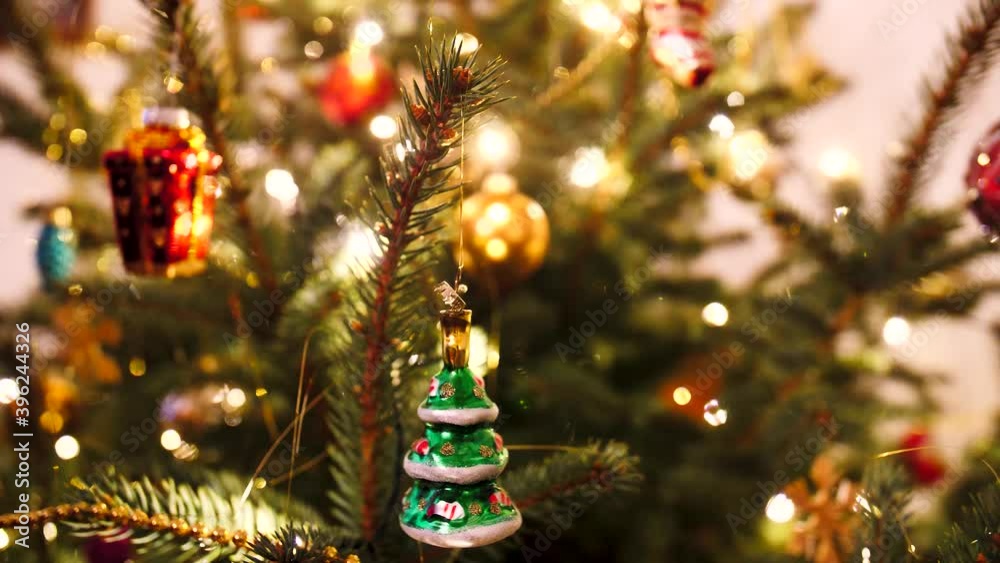 Geschmückter Weihnachtsbaum mit Christbaum Kugeln und russisches Spielzeug am Tannenbaum hängt und wackelt im Hintergrund Lichterkette X-Mas Advent Weihnachtsmann Geschenke 4k