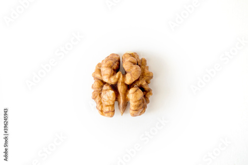 Half of a walnut looks like a brain on a white background.