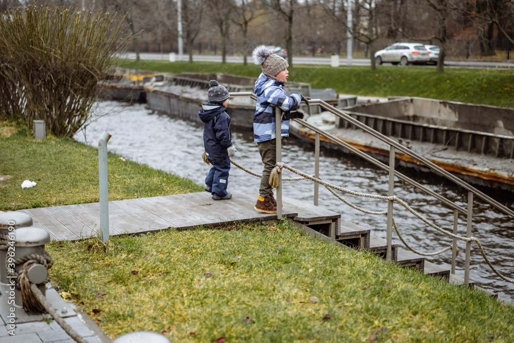 children watching boats transportation for cleaning up of rivers and chanells of saint petersburg. 