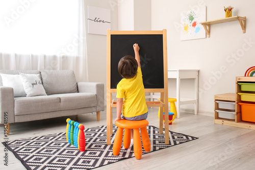 Cute little boy drawing on ...