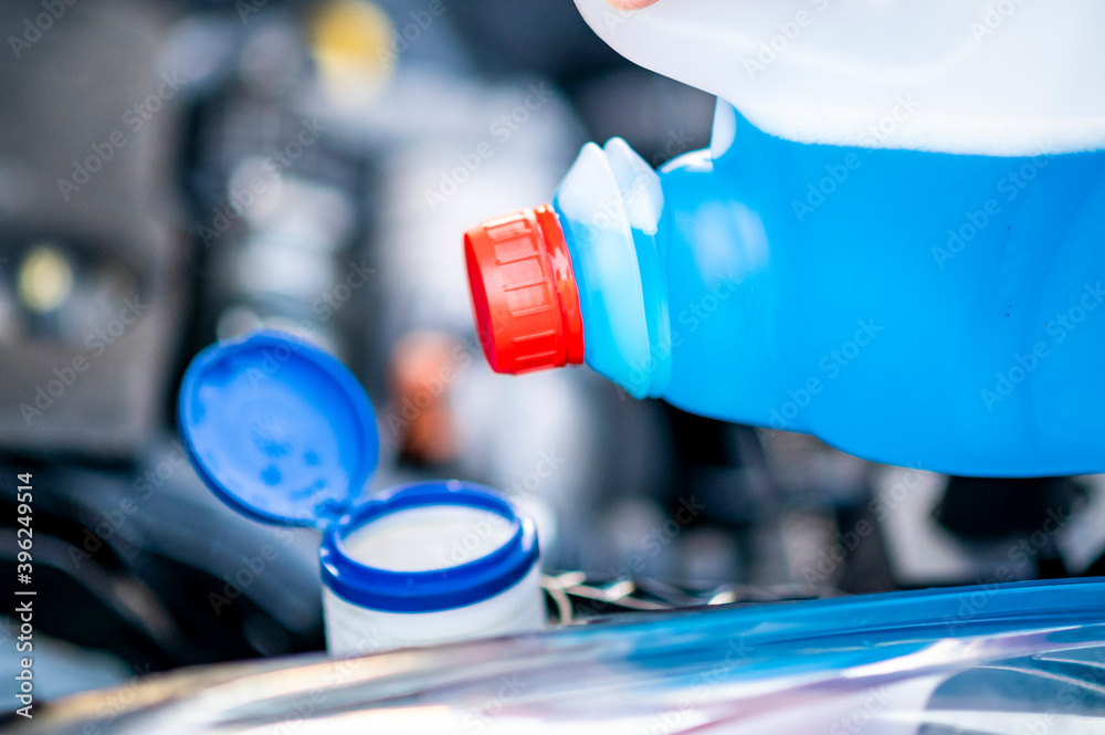 Pouring antifreeze. Filling a windshield washer tank with an antifreeze
