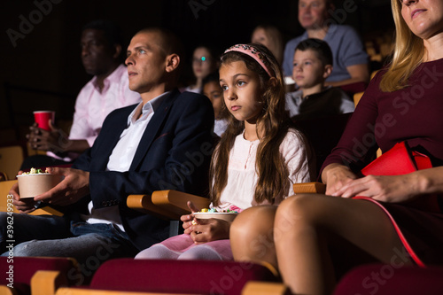 caucasian family sitting at premiere in cinema