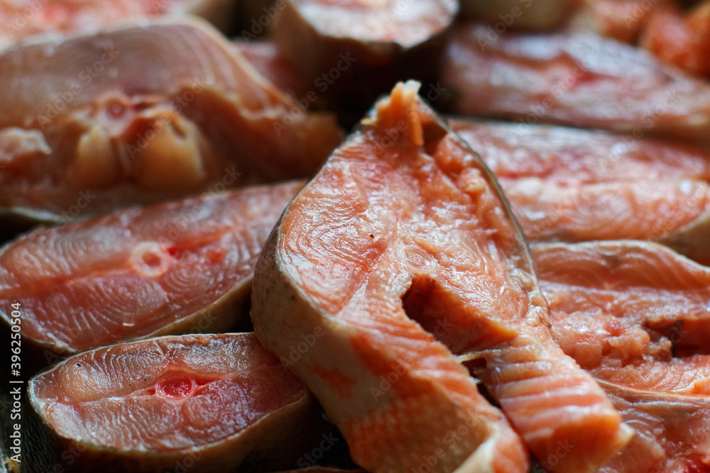 Sliced pieces of red fish are arranged in a row. Abstract background of chum salmon or pink salmon close-up.
