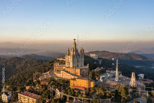 Aerial drone view of Basilica Sacred Heart on Mount Tibidabo near Barcelona during sunset golden hour