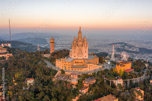 Aerial drone view of Basilica Sacred Heart on Mount Tibidabo near Barcelona during sunset golden hour
