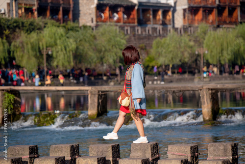 Tourists walking along Phoenix Ancient Town (Fenghuang County). Awesome view of scenic old street. Fenghuang is a popular tourist destination of Asia.