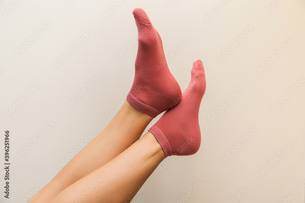 beautiful woman legs in new pink socks on a light background