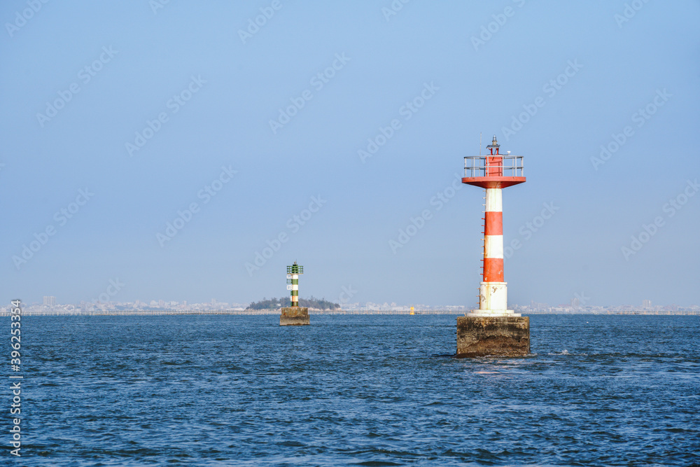 Lighthouse on the sea against blue sky and blue ocean surface Lighthouse on the sea against blue sky and blue ocean surface