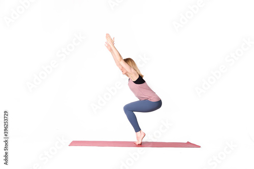 middle aged woman yoga asanas. instructor shows a pose from yoga isolated on a white background. woman practicing yoga concept natural balance between body and mental development.
