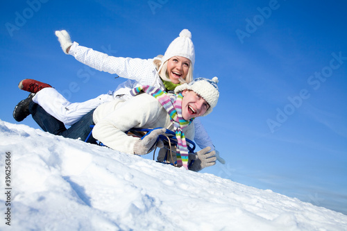 couple on sledge having fun
