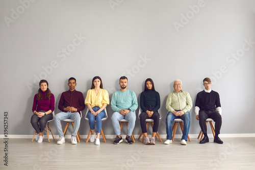 Multiethnic people sitting in corridor waiting for their turn to see doctor or to have job interview