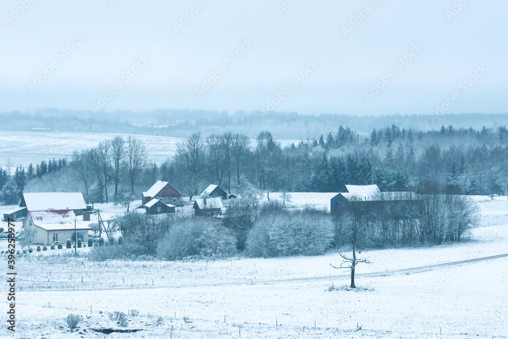 View from the hill  to winter landscape with farmstead  and forest, scenic winter view to valley, tranquil winter countryside, winter time concept 