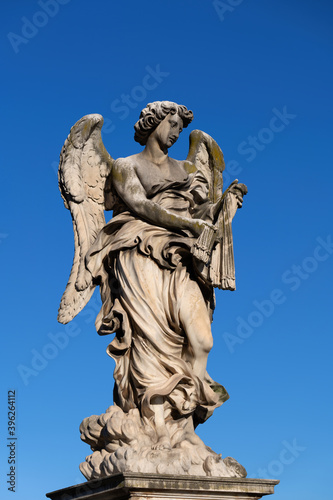 Angel with the Whips (Scourge) statue on Ponte Sant Angelo bridge in Rome, Italy. Marble sculpture from 17th century by Lazzaro Morelli