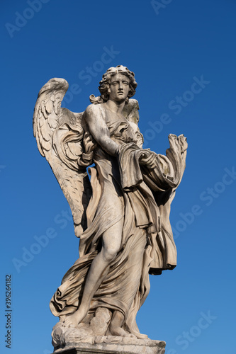 Angel with the Garment and Dice statue on Ponte Sant Angelo bridge in Rome  Italy. Marble sculpture from 17th century by Paolo Naldini