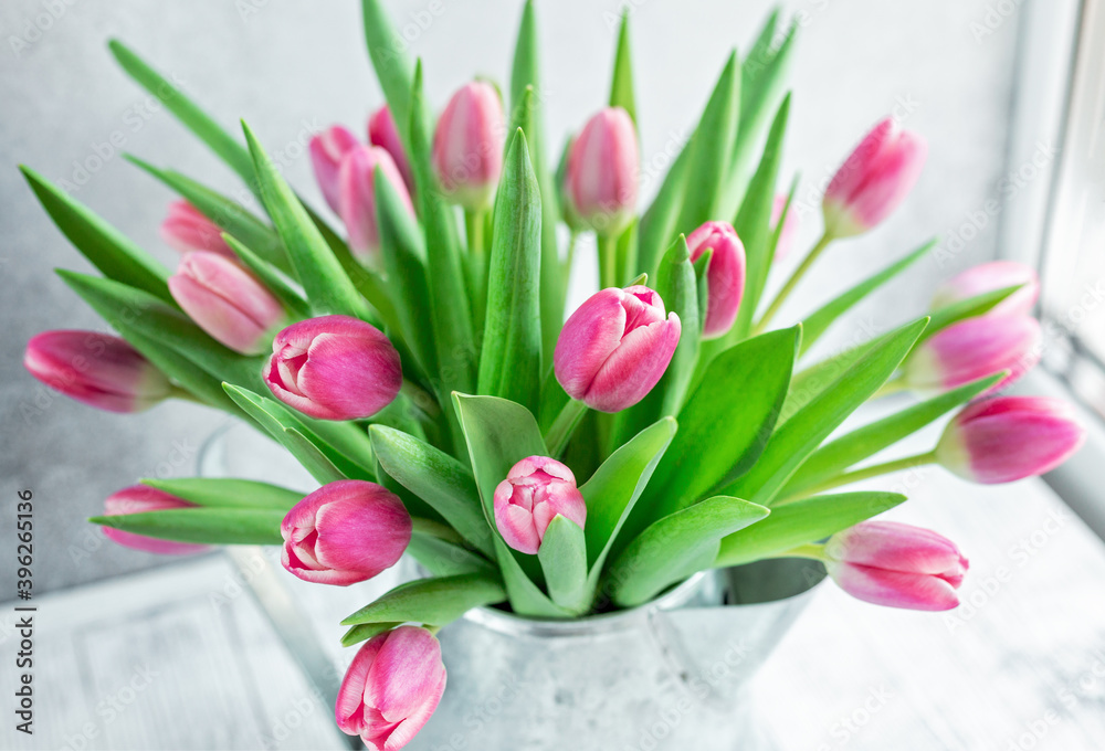 Spring floral background. Pink tulip flowers bouquet on on the windowsill. Copy space