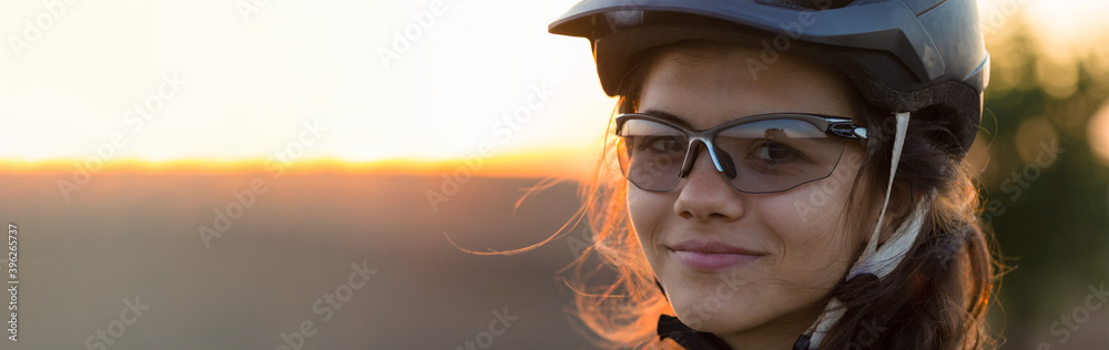 Young female cyclist cycling on rural road, side view.