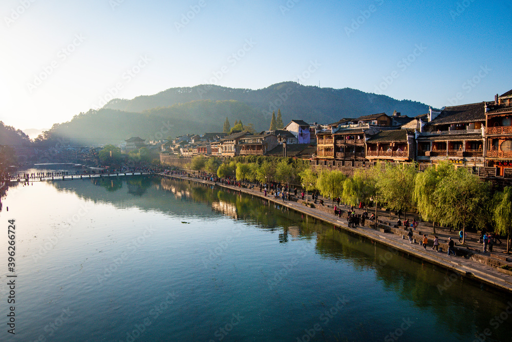 the river, the boat, stone bridge and the old houses at ancient phoenix town in the morning at Hunan, China. the river, the boat, stone bridge and the old houses at ancient phoenix town in the morning at Hunan, China.