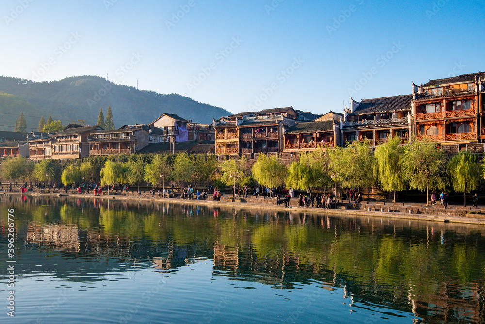 the river, the boat, stone bridge and the old houses at ancient phoenix town in the morning at Hunan, China.