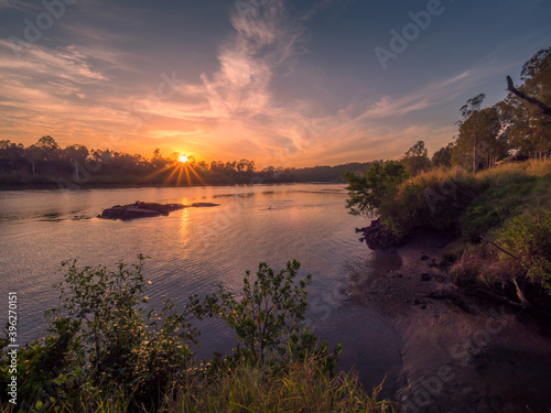 Beautiful Riverside Sunrise with Reflections and Sunburst