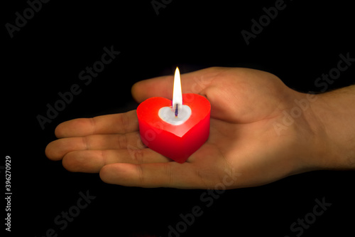 Heart shaped candle in hand