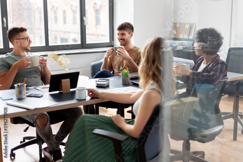 business, people and corporate concept - team of startuppers drinking coffee at office