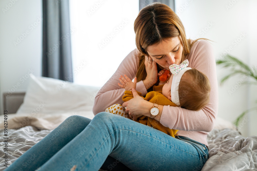 Mother and baby daughter plays, hugging, kissing at home. Happy family. Mother and baby daughter plays, hugging, kissing at home. Happy family.