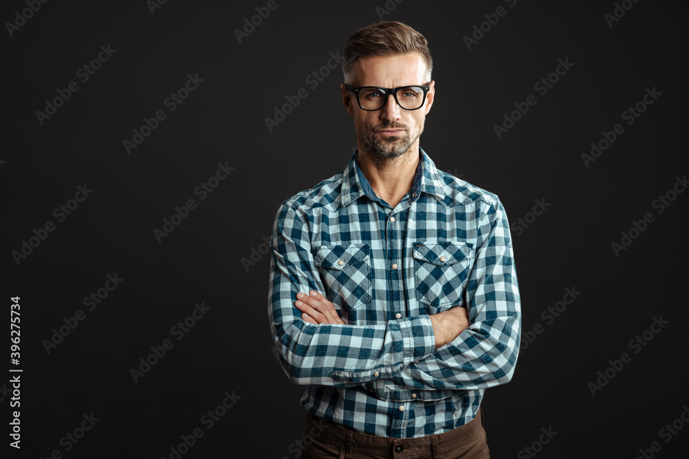 Handsome confident man in eyeglasses posing with arms crossed Handsome confident man in eyeglasses posing with arms crossed