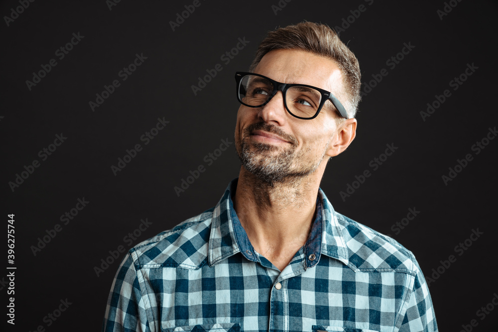 Obraz premium Handsome pleased man in eyeglasses posing and looking aside