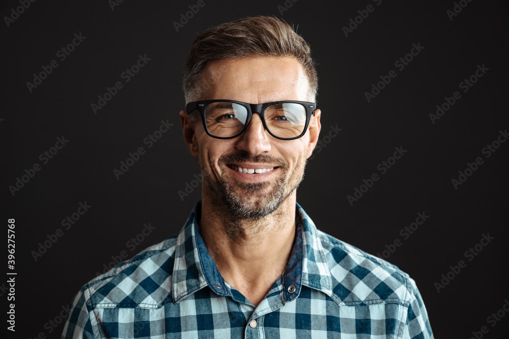 Handsome joyful man in eyeglasses smiling and looking at camera Handsome joyful man in eyeglasses smiling and looking at camera