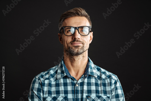 Handsome pleased man in eyeglasses posing and looking upward © Drobot Dean