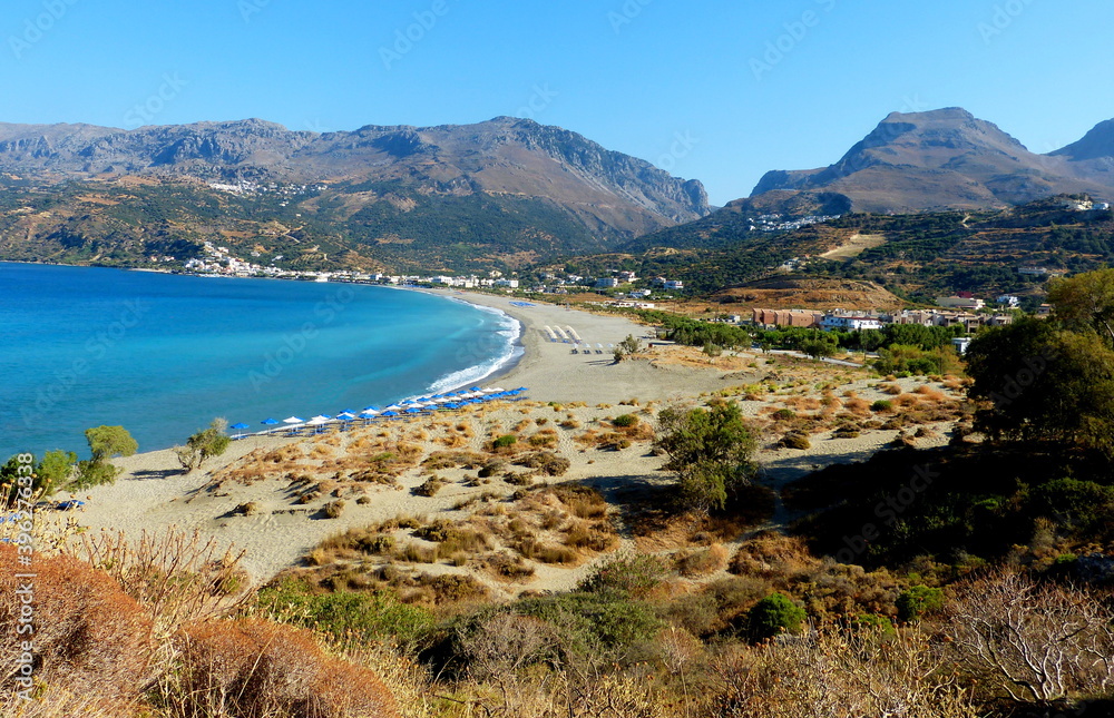 Mediterranean scenic coast Crete island at summertime, blue calm Lybean sea, long sand beach, majestic mountains, Plakias greek Village.