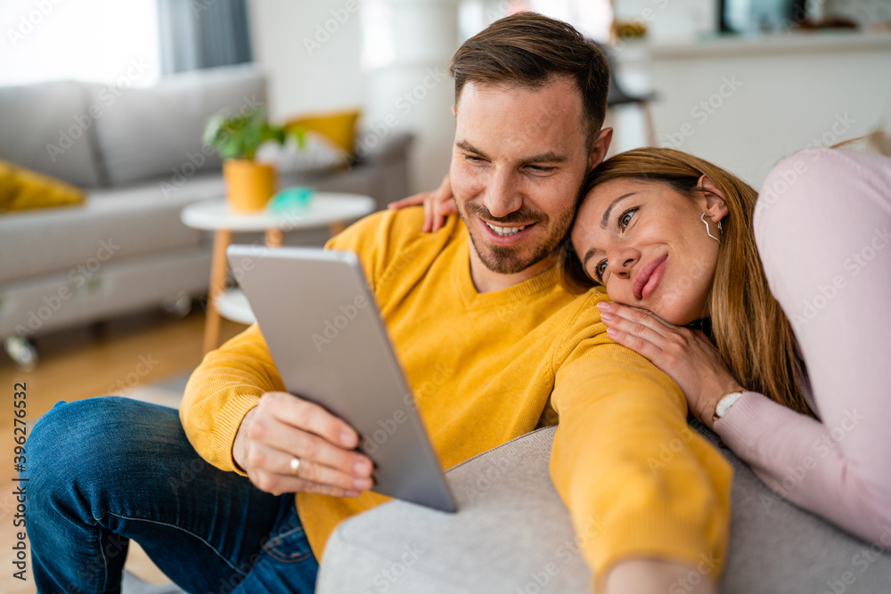 Happy cheerful couple in love using digital tablet at home
