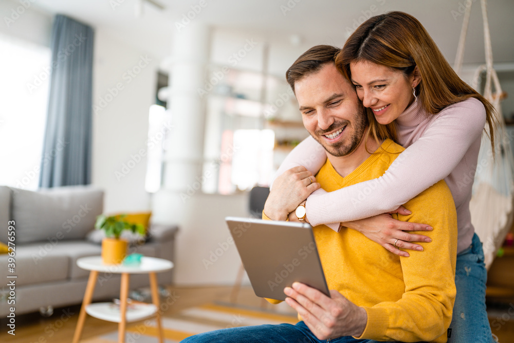 Couple in love hugging and using tablet together. Couple in love hugging and using tablet together.