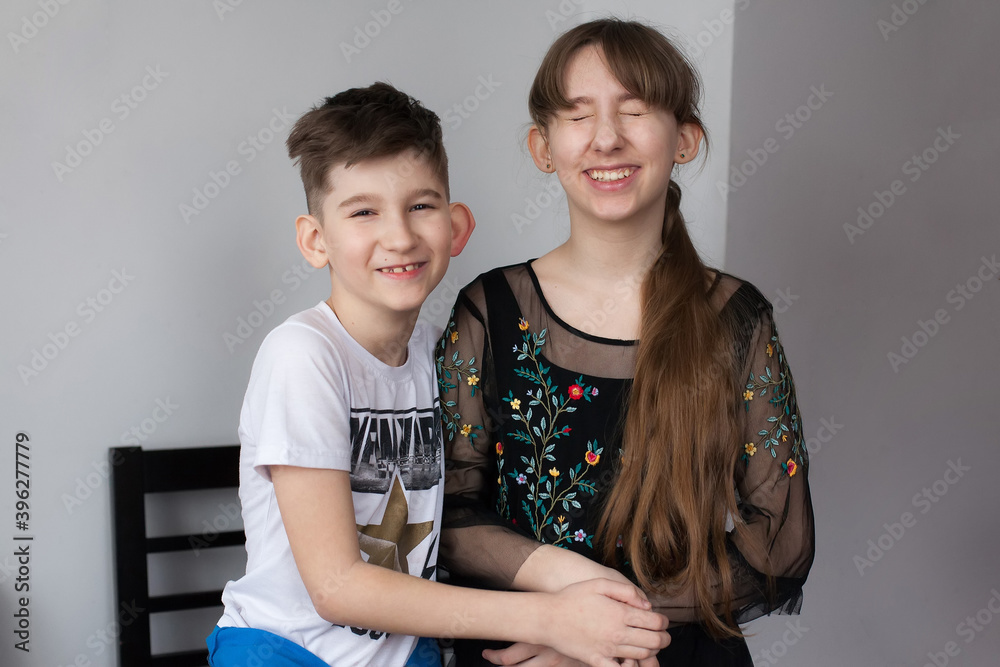 Brother and sister hugging each other. Pretty girl and young boy cuddling. Puppy love, relationships and childhood. Happy family Brother and sister hugging each other. Pretty girl and young boy cuddling. Puppy love, relationships and childhood. Happy family