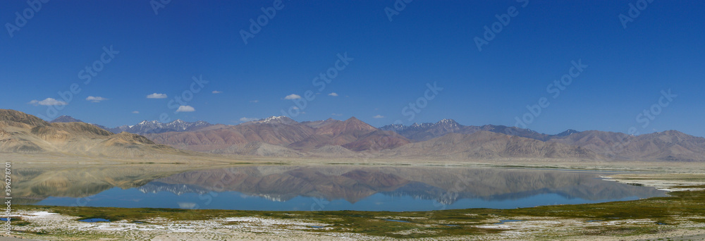 Panoramic view of high-altitude Sassykkul lake with mountain background and reflection along Pamir Highway, Alichur, Gorno-Badakshan, Tajikistan
