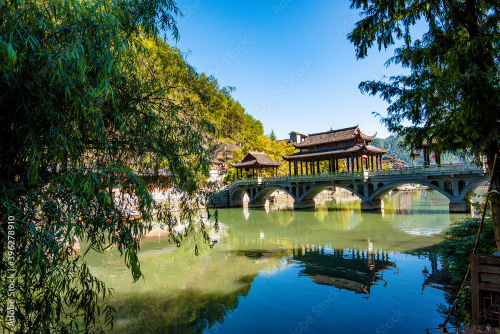 the river, the boat, stone bridge and the old houses at ancient phoenix town in the morning at Hunan, China.