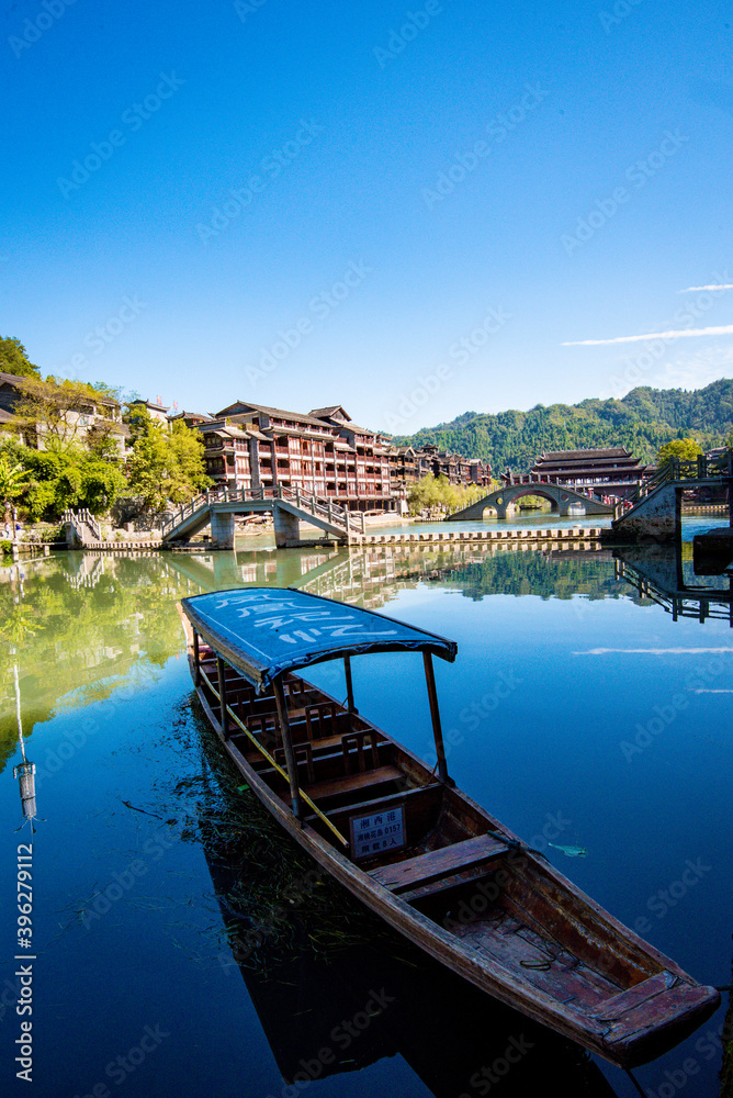 Obraz premium the river, the boat, stone bridge and the old houses at ancient phoenix town in the morning at Hunan, China.