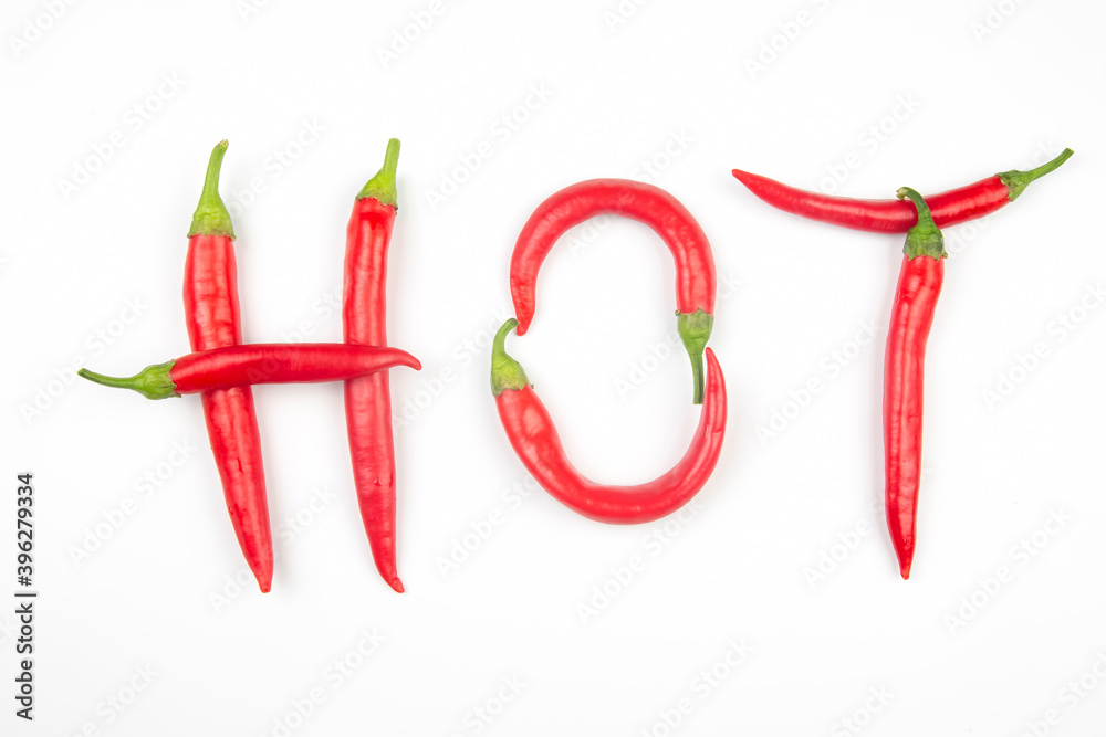 Red hot chili peppers are lined with letters on a white background. Vitamin vegetable food