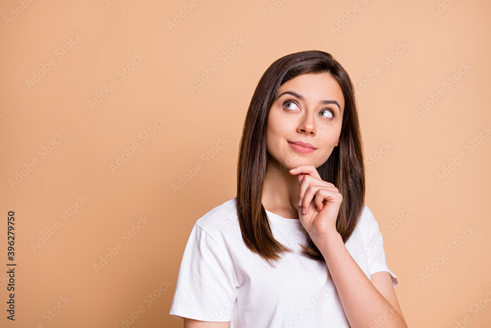 Photo portrait of dreamy girl thoughtful looking copyspace touching chin isolated pastel beige color background Photo portrait of dreamy girl thoughtful looking copyspace touching chin isolated pastel beige color background