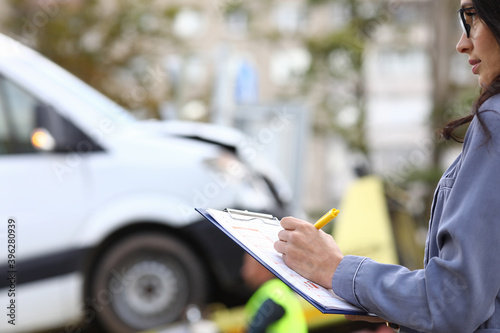 An agent fills out paperwork after car accident. Vehicle insurance concept