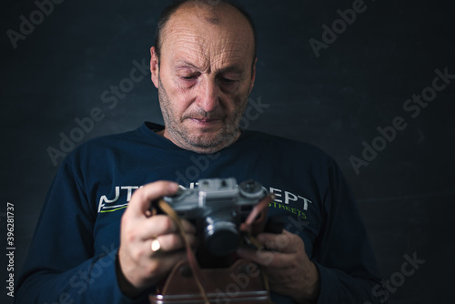 Older photographer check his film camera