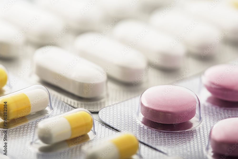 Heap of medical pills in white and other colors. Pills in plastic package. Concept of healthcare and medicine. Heap of medical pills in white and other colors. Pills in plastic package. Concept of healthcare and medicine.