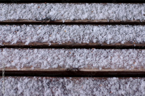 the first snow on the boards of a wooden bench