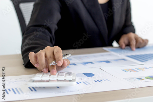 A female accountant is using a calculator.