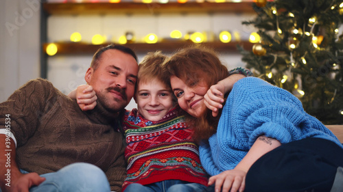 Cheerful family sitting together on couch at living room on christmas eve