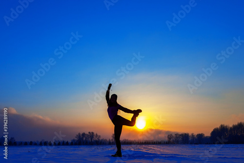 silhouette of a sports girl at sunset in winter