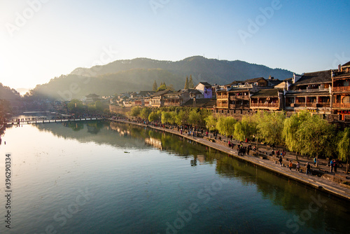 the river, the boat, stone bridge and the old houses at ancient phoenix town in the morning at Hunan, China. 