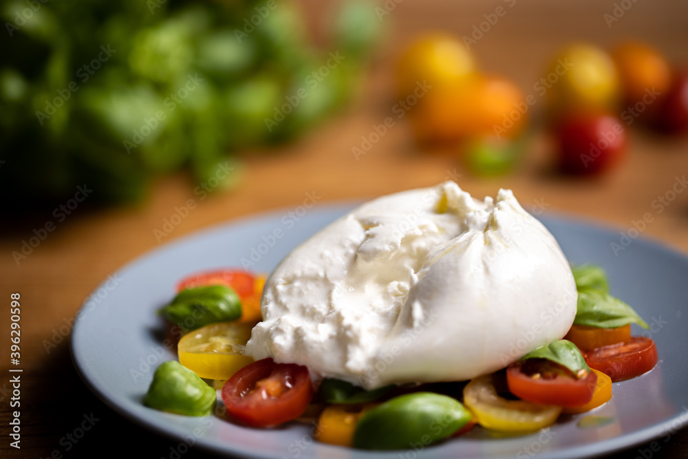 Burrata cheese on colourful tomato and basil salad Burrata cheese on colourful tomato and basil salad