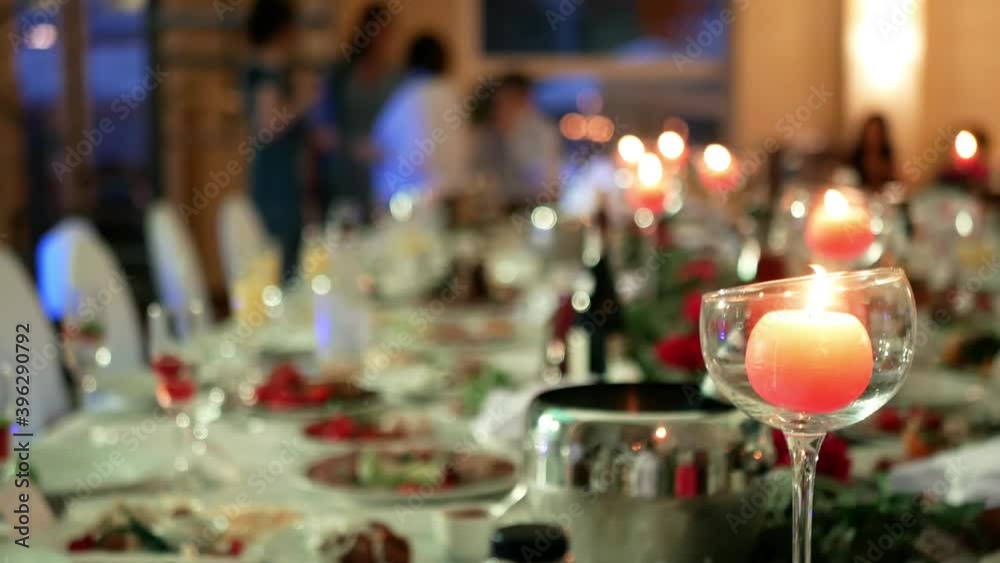 Celebration of solemn joyful holidays. Birthday anniversary. Guests at the Festive table with treats and candles Celebration of solemn joyful holidays. Birthday anniversary. Guests at the Festive table with treats and candles